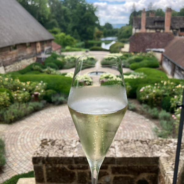A glass of nyetimber classic cuvee in front of their famous manicured garden.